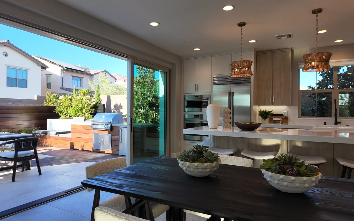Kitchen and dining opening to a deck and outdoor kitchen through a full-width slider, NHG HOME project, Orange County